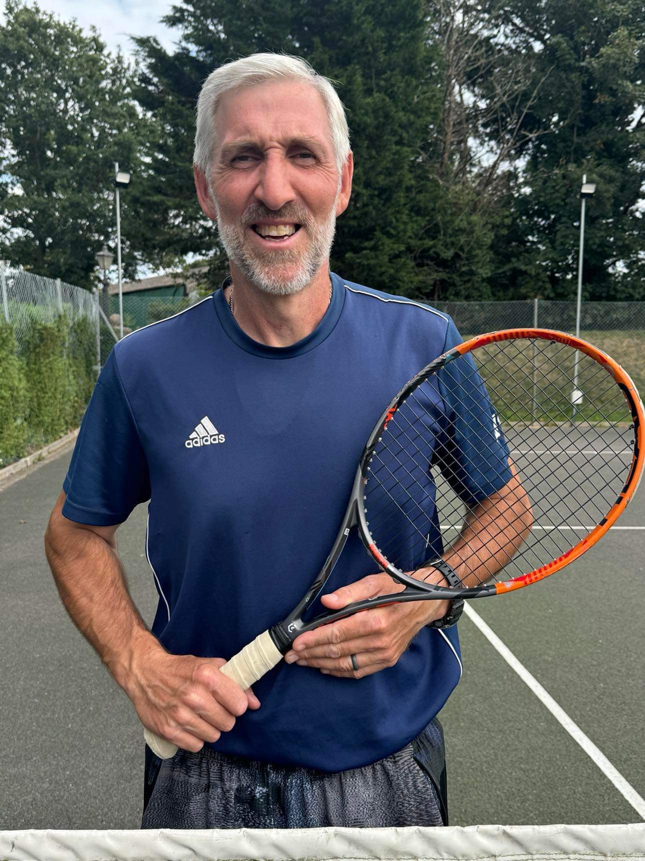 Rob Norris holding a tennis racket on court